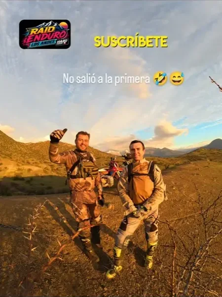 Dos pilotos de enduro celebrando al atardecer durante el reconocimiento de la ruta.