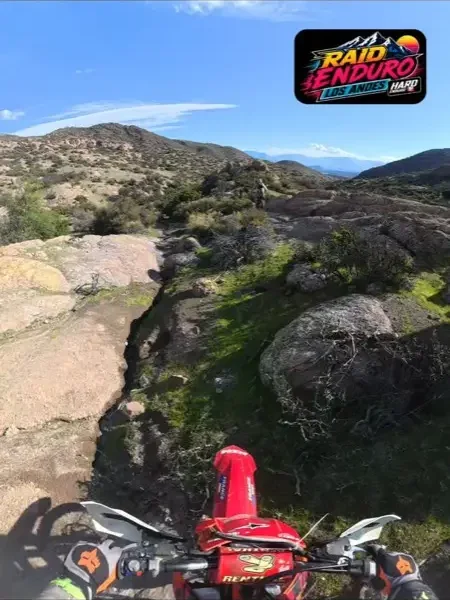 Vista desde la moto en un sendero rocoso con la cordillera al fondo.